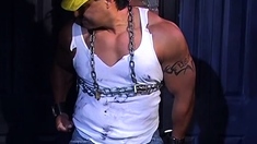 Muscular construction worker is bound up with chains