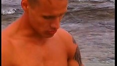 Tattooed muscular buddy gets naked and masturbates on a sunny beach